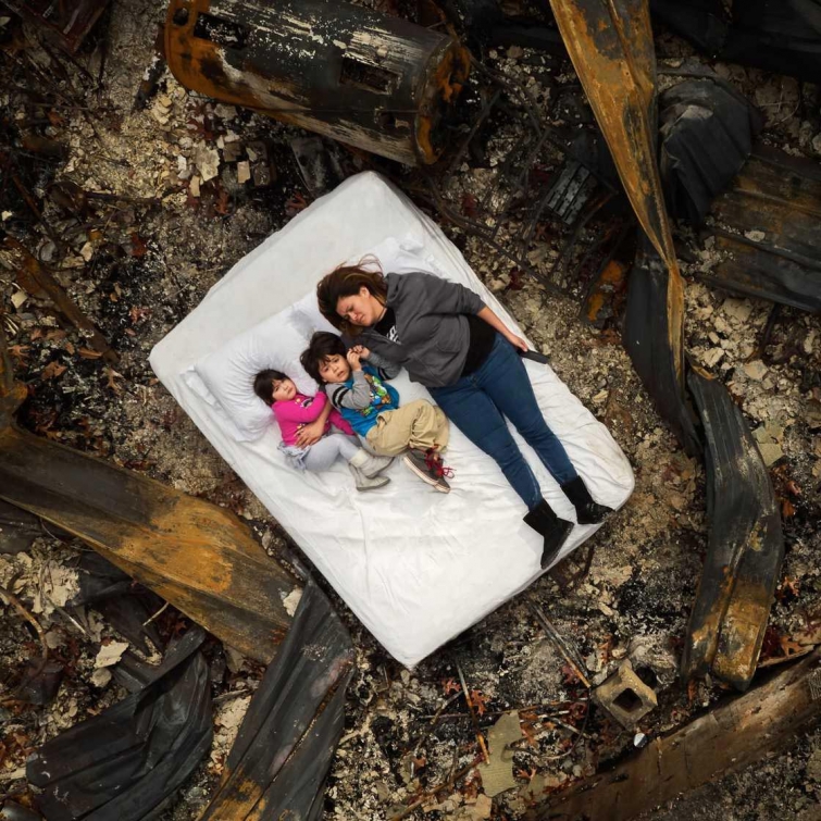 Жертвы лесных пожаров, лежащие на сгоревших развалинах своих домов 