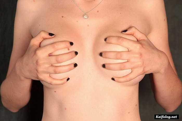 женщина прикрывает голую грудь